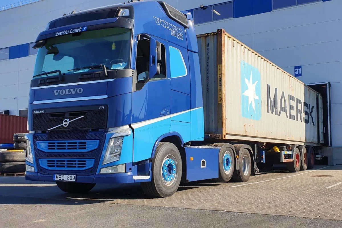 Volvo vilkikas su MAERSK konteineriu prie sandėlio